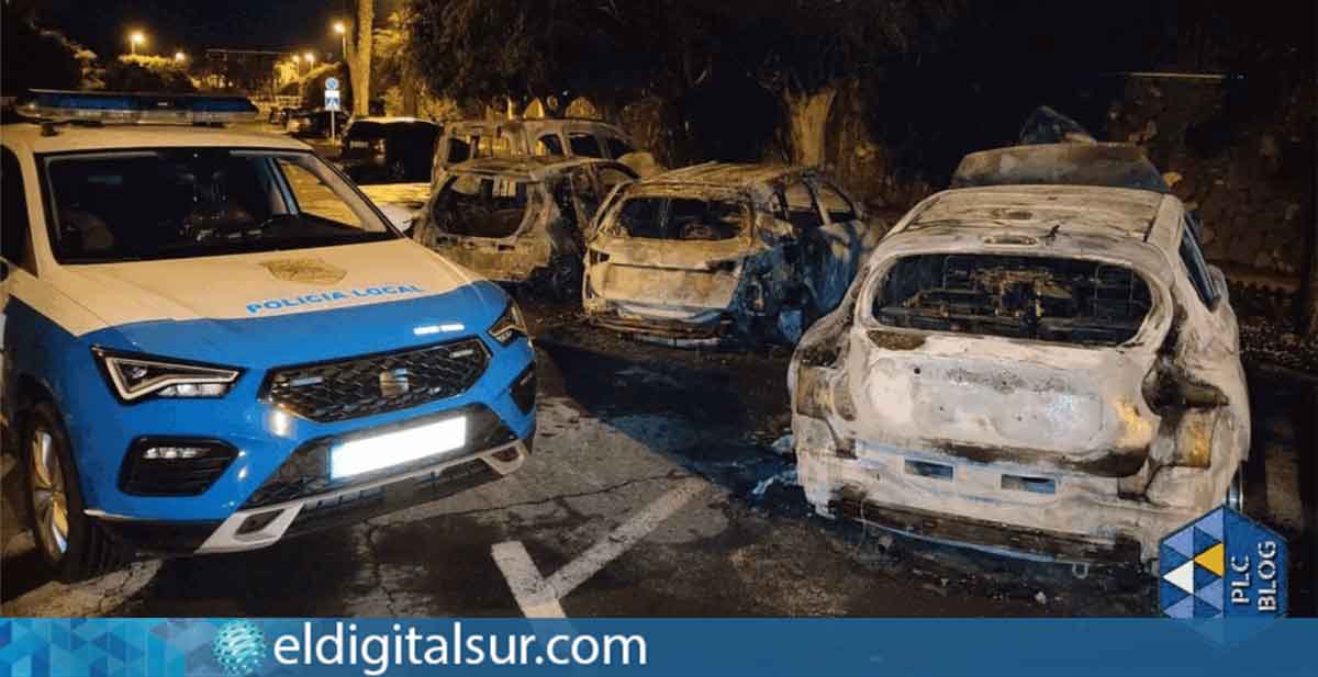 Coches destruidos por el fuego en la calle La Marea, junto a una patrulla de la Policía Local de Arona