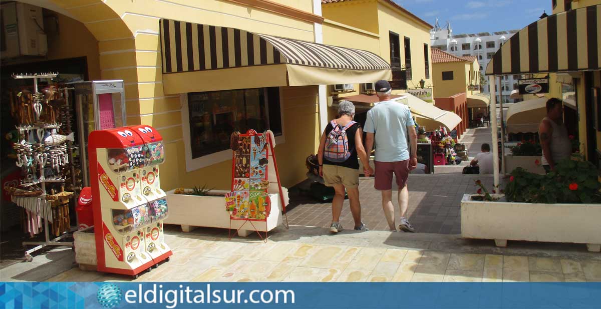 Turistas pasean frente a los comercios de Golf del Sur