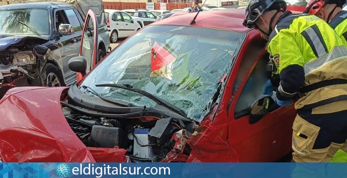 Bomberos del Consorcio de Tenerife trabajan en la liberación de un ocupante atrapado tras la colisión frontal ocurrida en Las Rosas, Arona