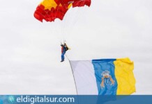 Momento en que los paracaidistas de la PAPEA despliegan en el cielo la Bandera de España y la Bandera Canaria ante miles de asistentes en la playa de Santa Cruz de La Palma
