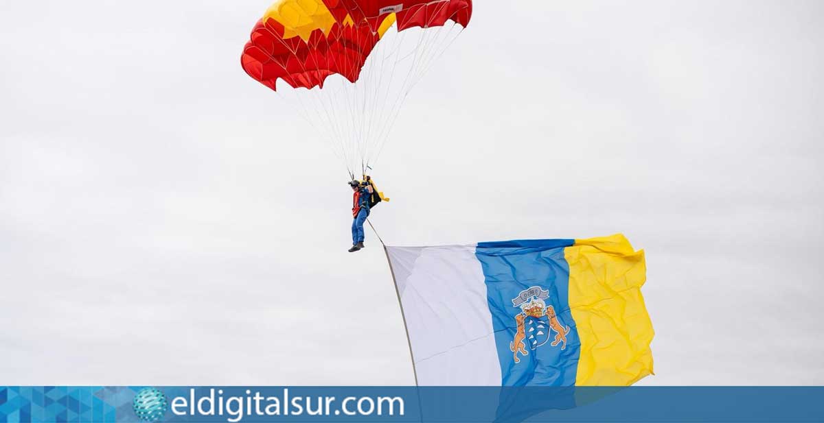Momento en que los paracaidistas de la PAPEA despliegan en el cielo la Bandera de España y la Bandera Canaria ante miles de asistentes en la playa de Santa Cruz de La Palma