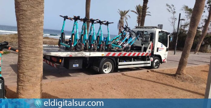 Camión cargando patinetes eléctricos retirados de la vía pública