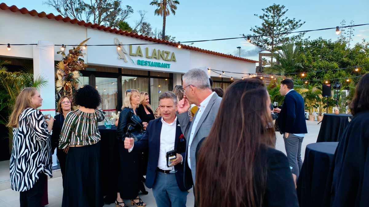 Gente disfrutando de la inauguración frente a la entrada del restaurante del complejo