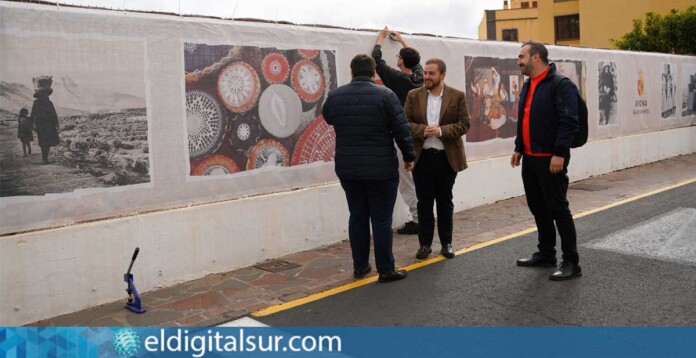 Instalación de la lona con fotografías históricas en la calle Duque de la Torre, en el casco histórico de Arona