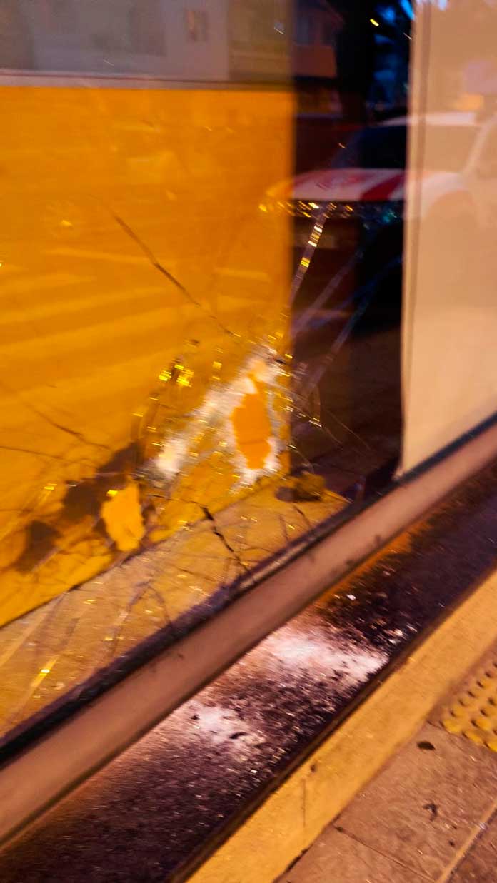 Una de las piedras utilizadas durante el ataque quedó en el interior de la sucursal tras atravesar la cristalera