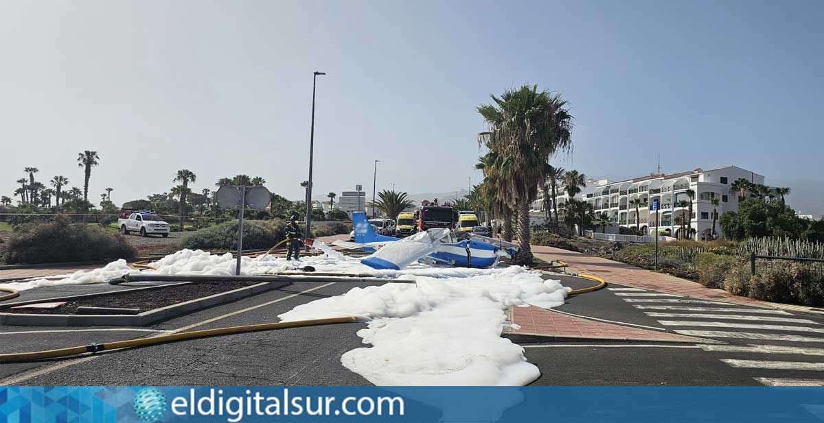 Efectivos de bomberos intervienen junto a la avioneta tras el aterrizaje de emergencia registrado en una calle de San Miguel de Abona, donde fue necesario actuar ante el derrame de combustible sobre la vía