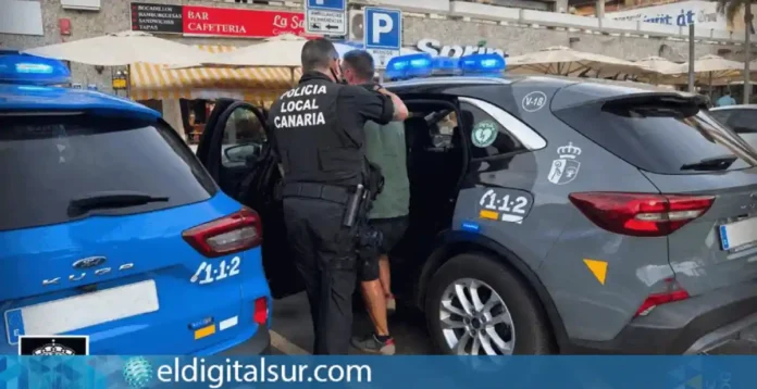Agente de la Unidad de Prevención Policial introduciendo a uno de los detenidos en un patrulla