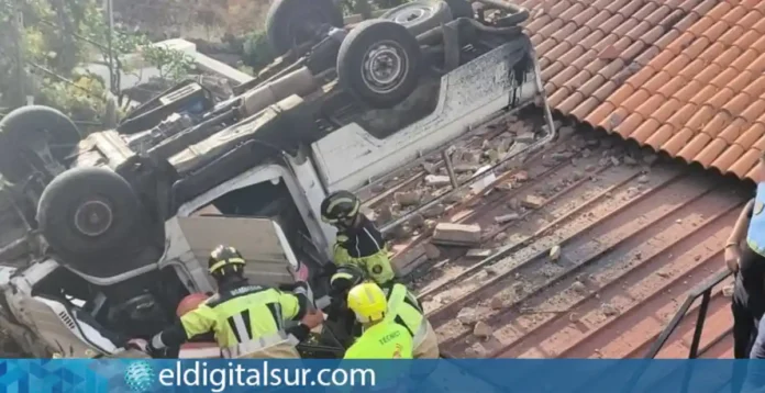 Los bomberos trabajan en el rescate del conductor atrapado en el vehículo tras precipitarse sobre la azotea de una vivienda en Santa Úrsula.