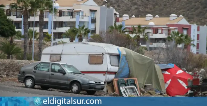 Una vivienda improvisada en primer plano, con edificios residenciales al fondo